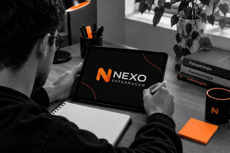 Estudante de enfermagem estudando em um tablet, com livros de fisiopatologia, farmacologia e enfermagem sobre a mesa